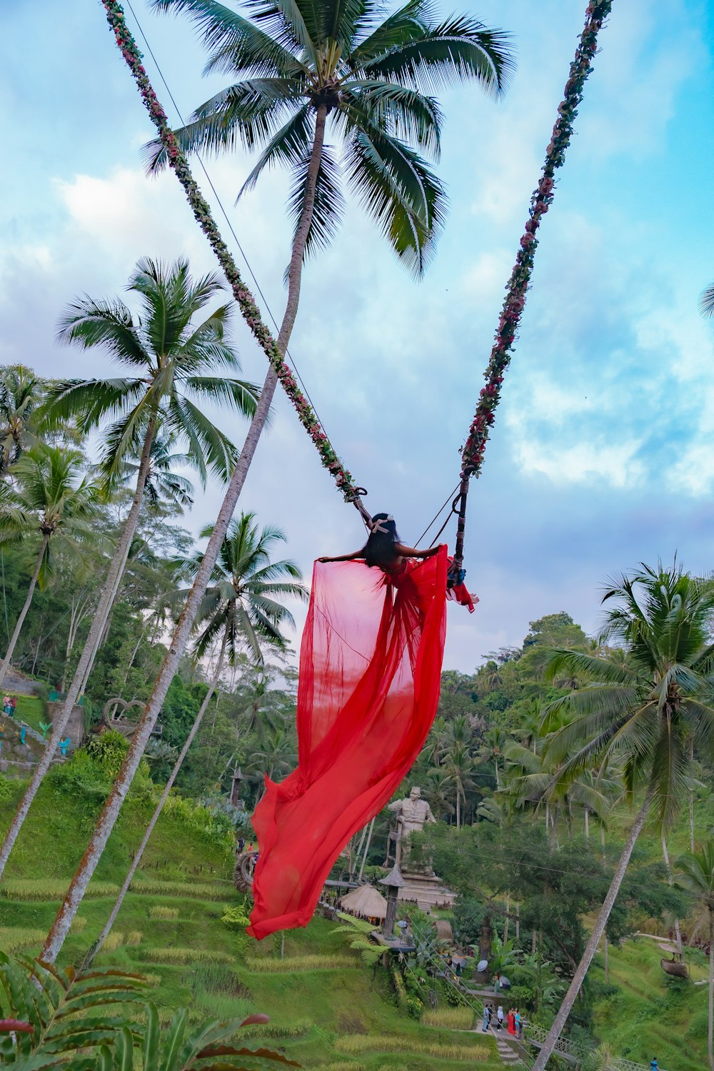 a red scarf hanging from a palm tree