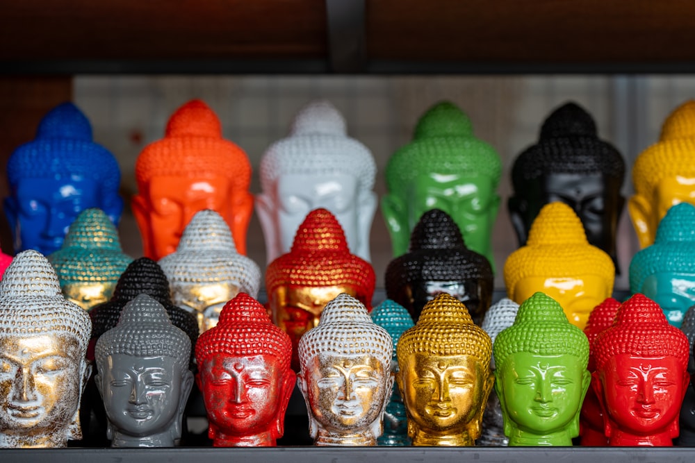 a group of buddha heads sitting on top of a shelf