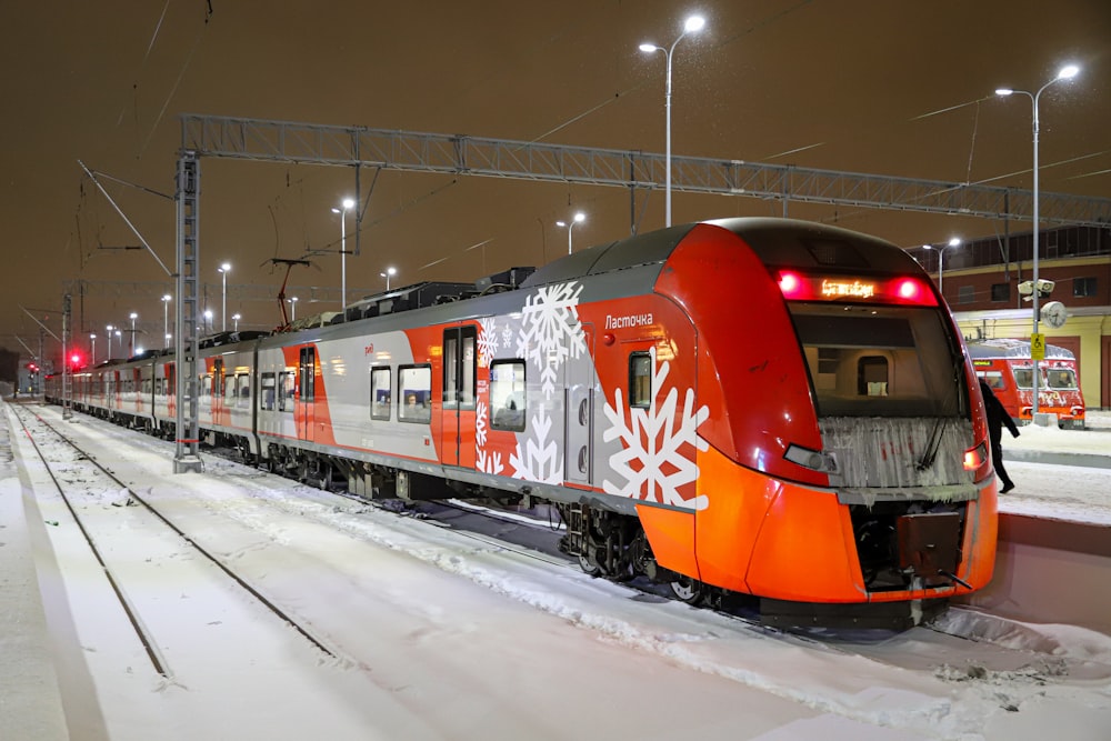 a red and white train traveling down train tracks