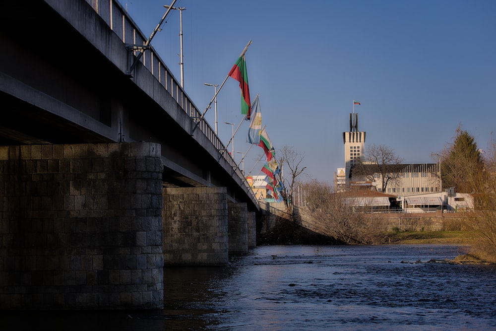 a bridge over a river with a building in the background