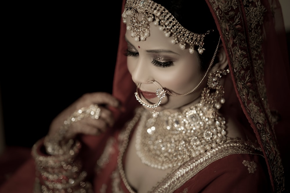 a woman in a red and gold bridal outfit