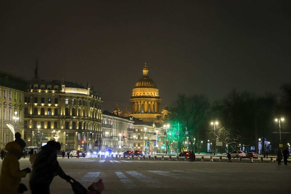 a city street at night with people walking around