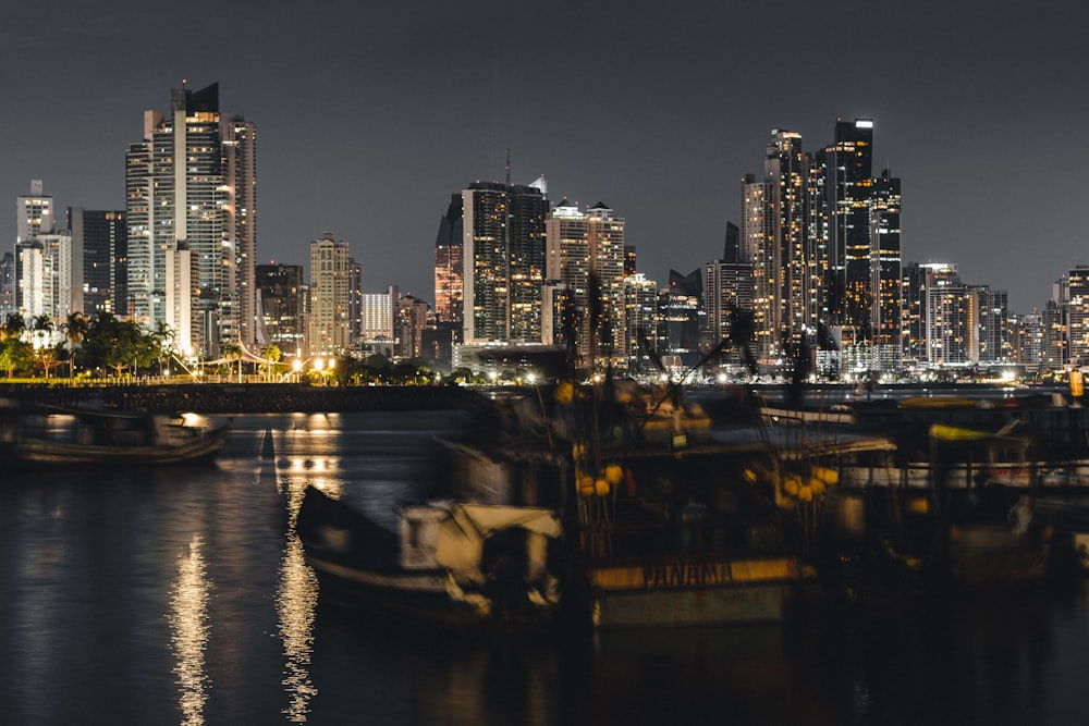 a city skyline at night with boats in the water