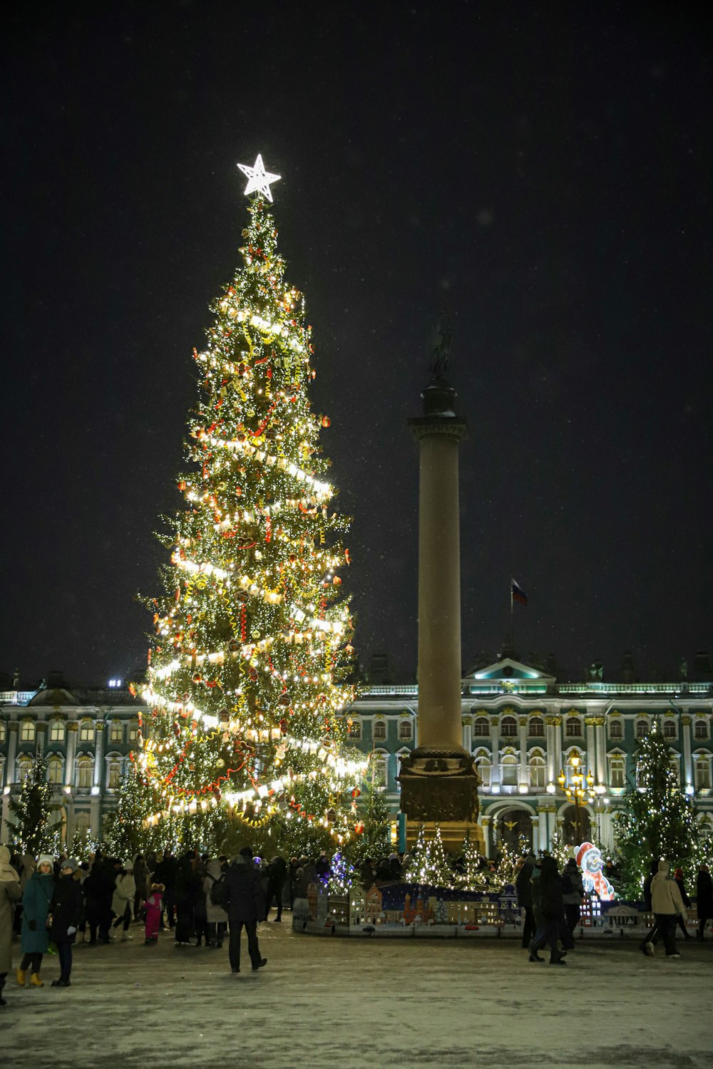 a large christmas tree is lit up in front of a building