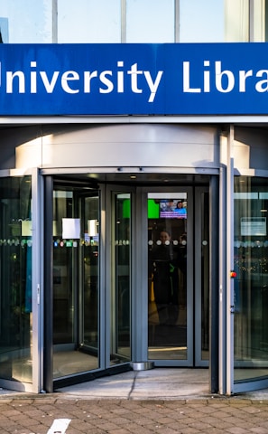 a university library entrance with a bicycle parked in front of it