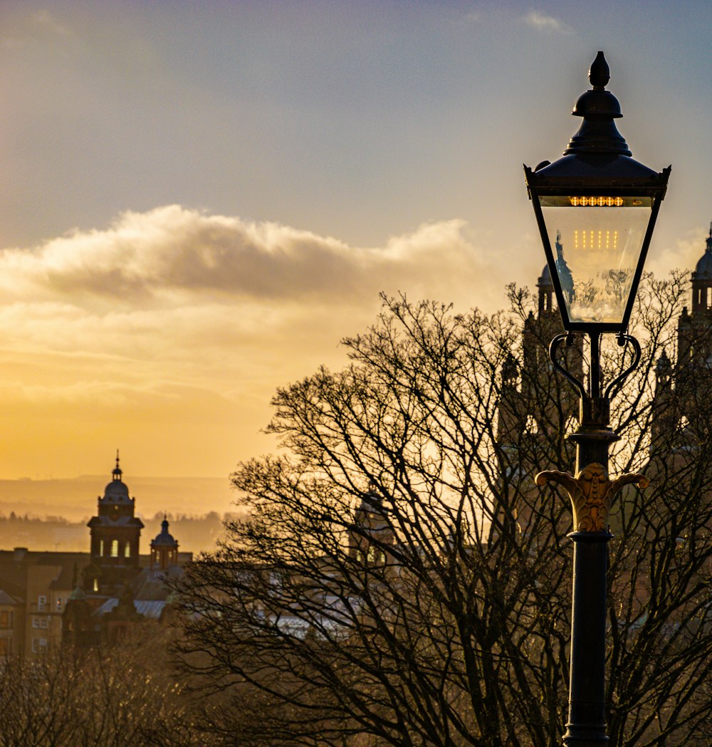 a lamp post in front of a building with a clock tower in the background