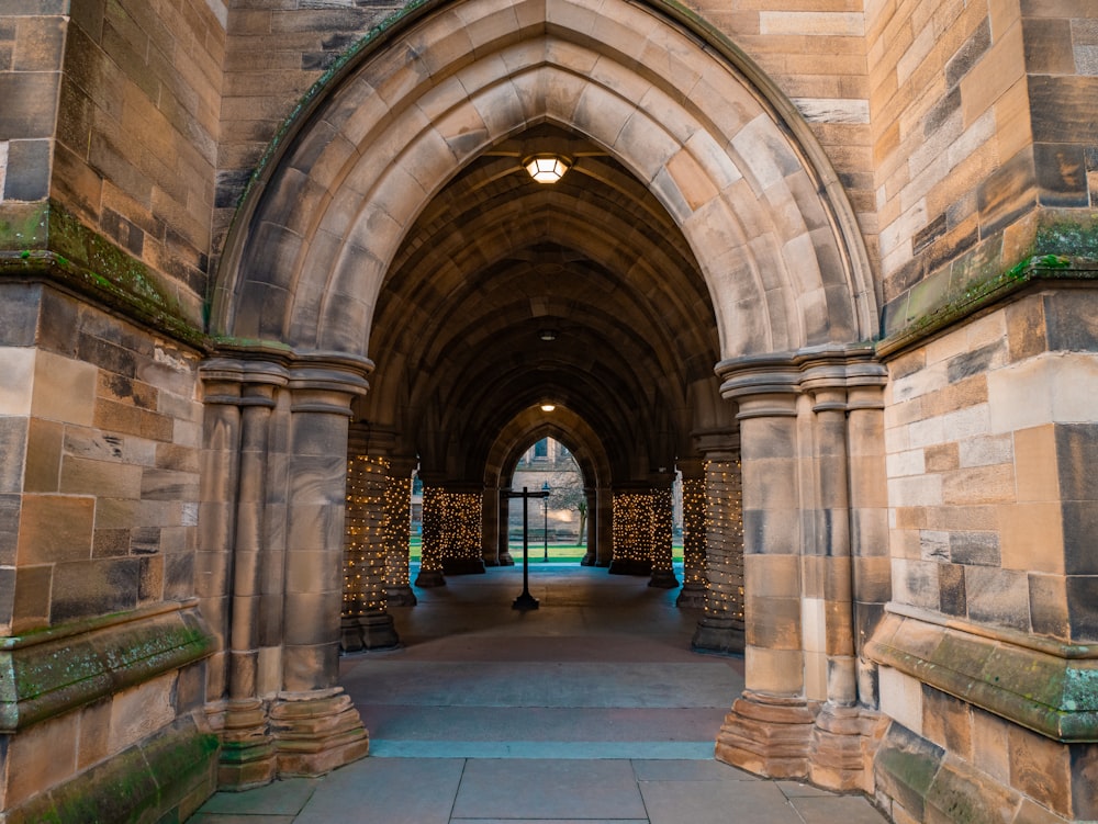 a stone archway with a clock on the wall