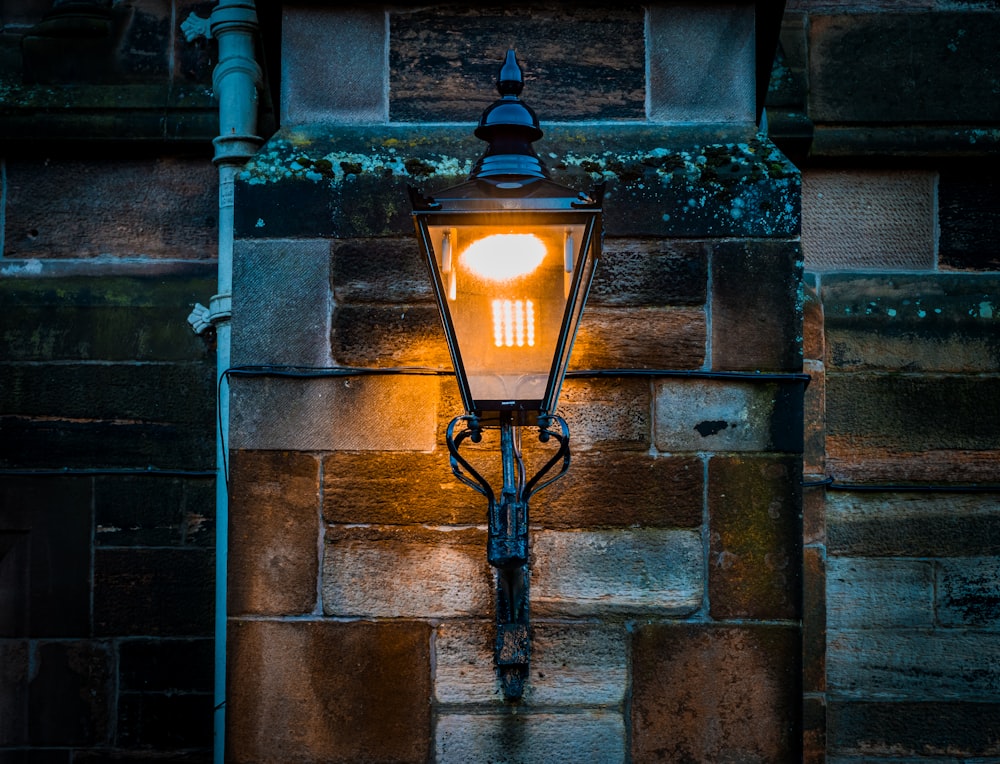 a street light on a brick wall in the dark