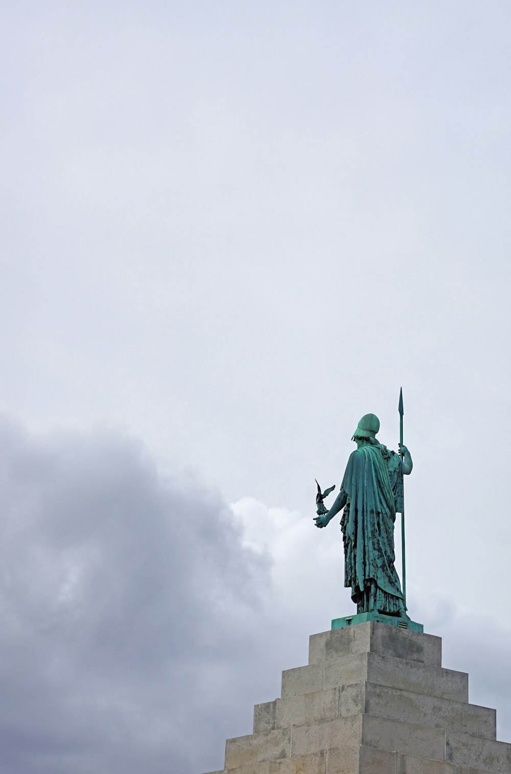 una estatua de un hombre con una espada en lo alto de un edificio