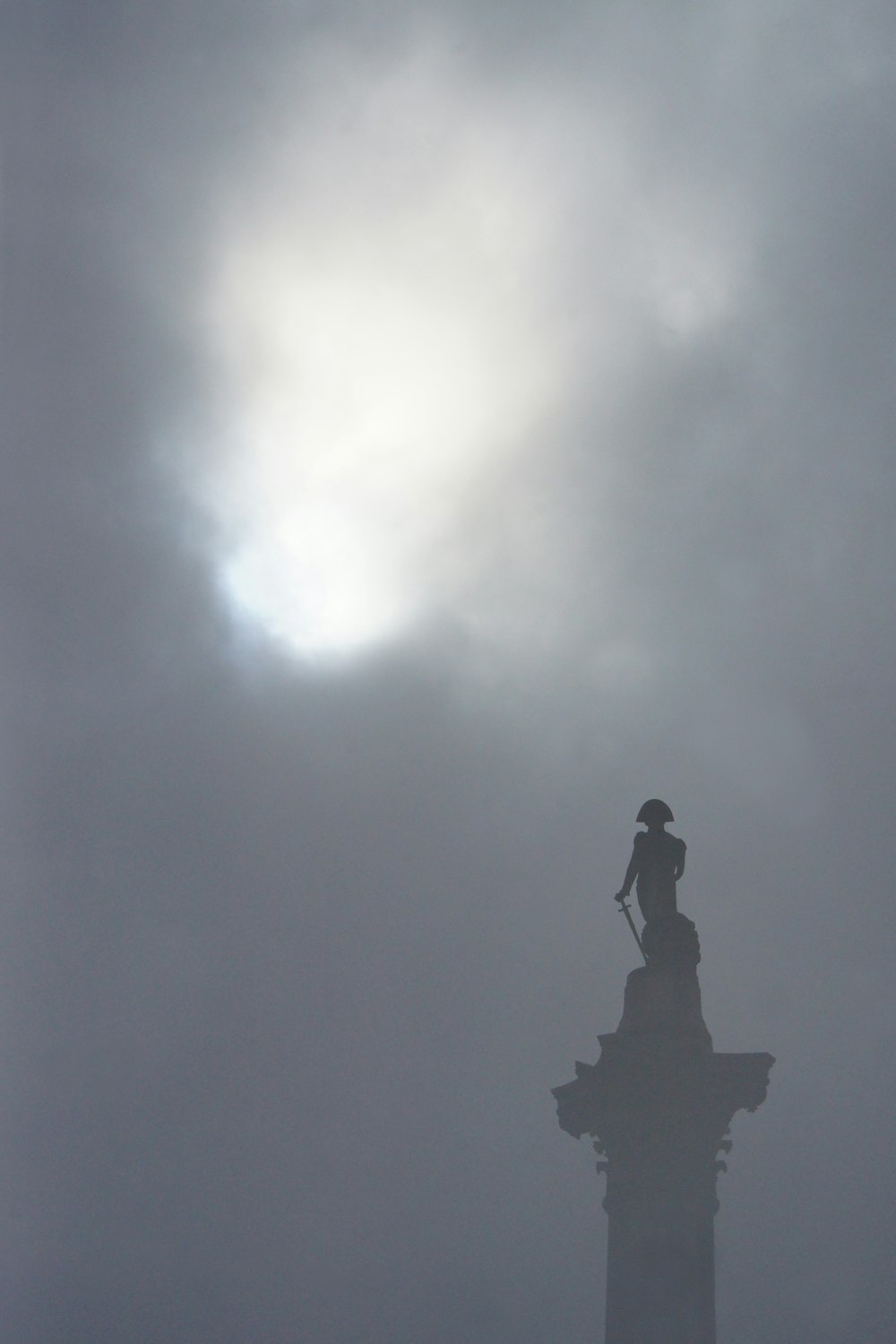 una statua in cima a un edificio nella nebbia