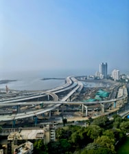an aerial view of a highway near a large body of water