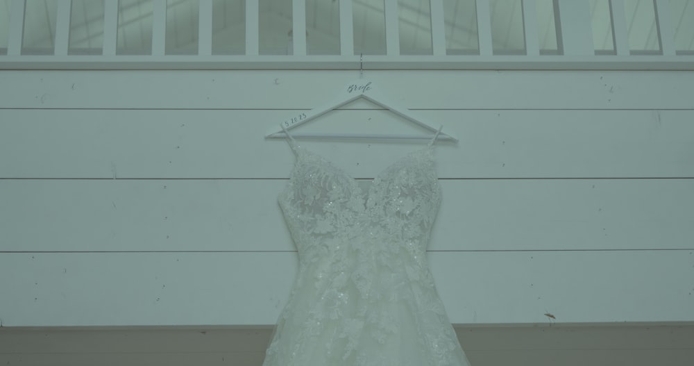 a wedding dress hanging on a hanger