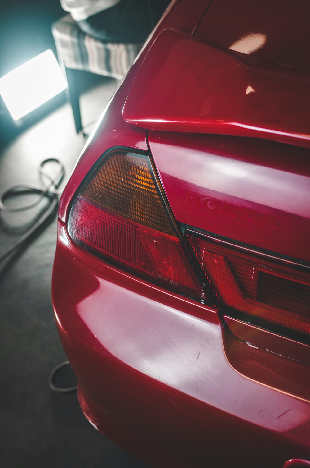 a red car parked in a garage next to a charger