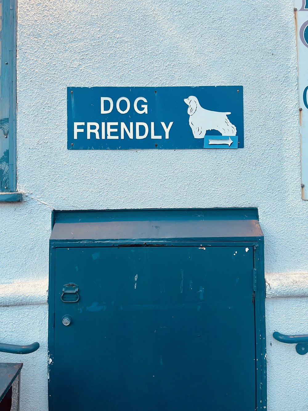 un cartello dog friendly sul lato di un edificio