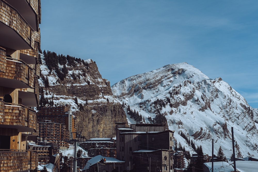 a snow covered mountain in the background with buildings in the foreground