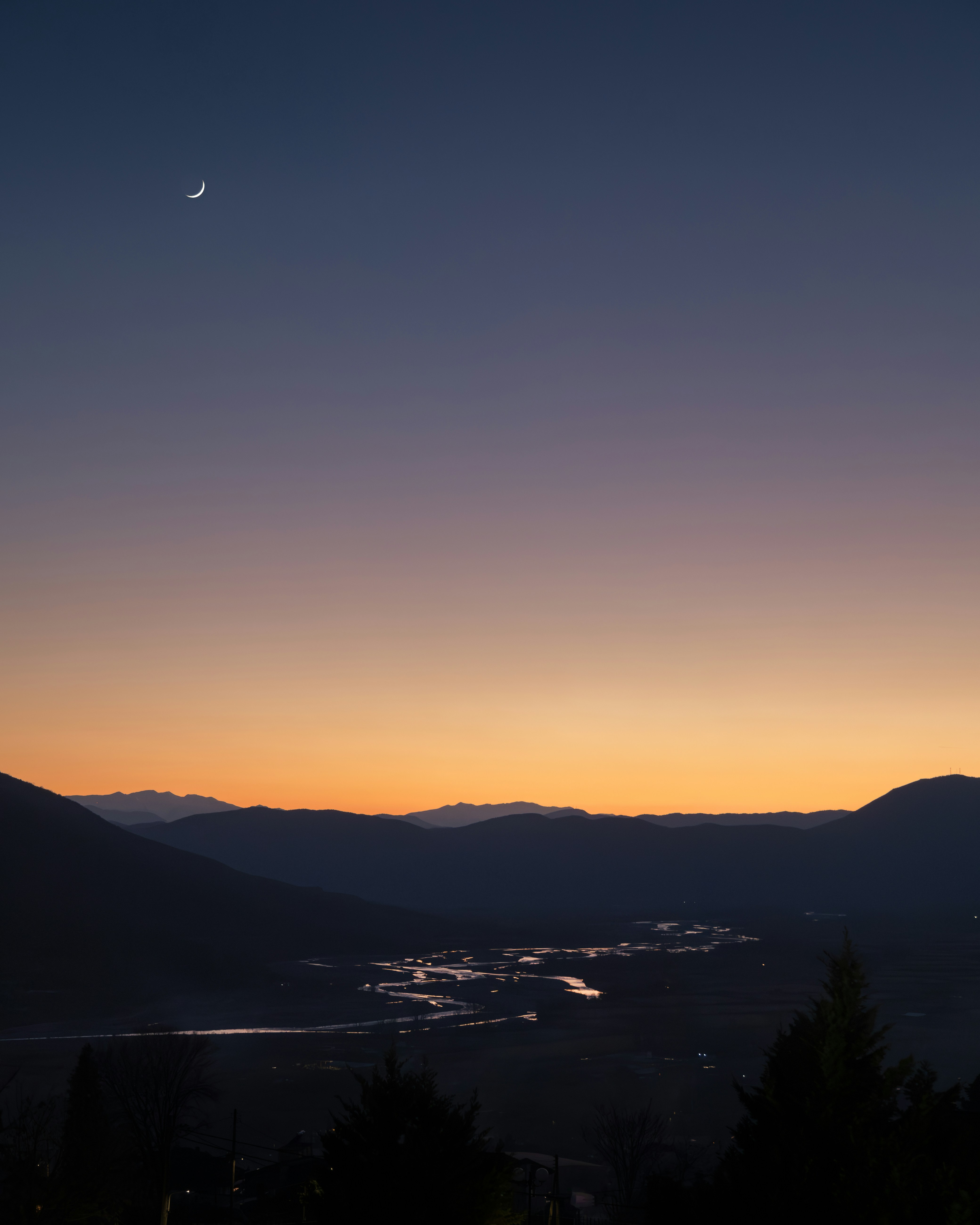 the sun is setting over a mountain range