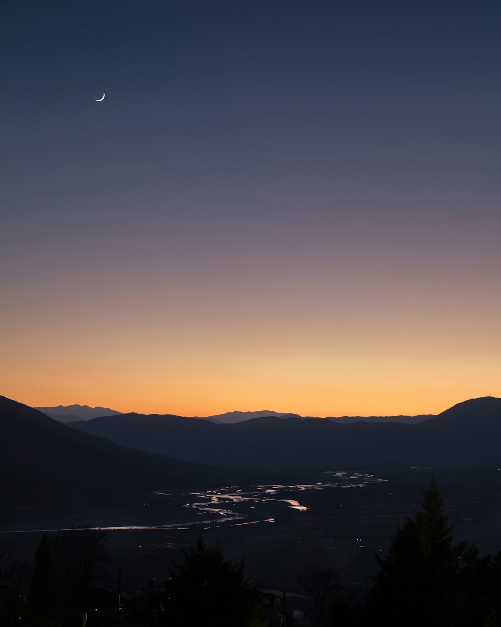 the sun is setting over a mountain range