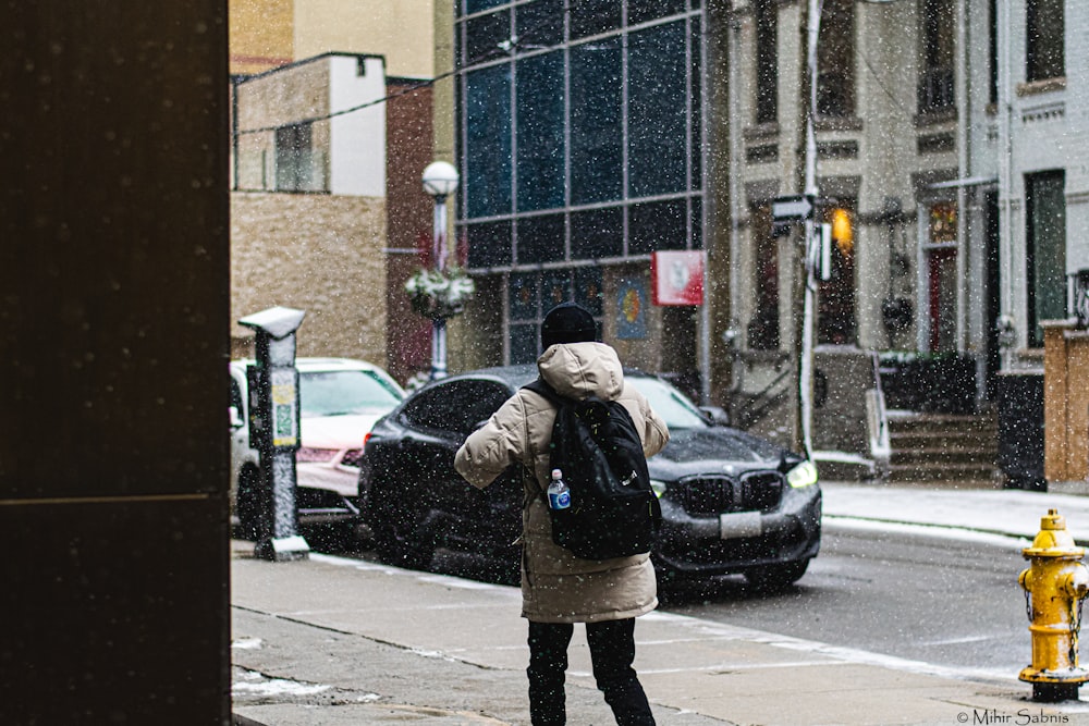 a woman standing on a sidewalk in the rain