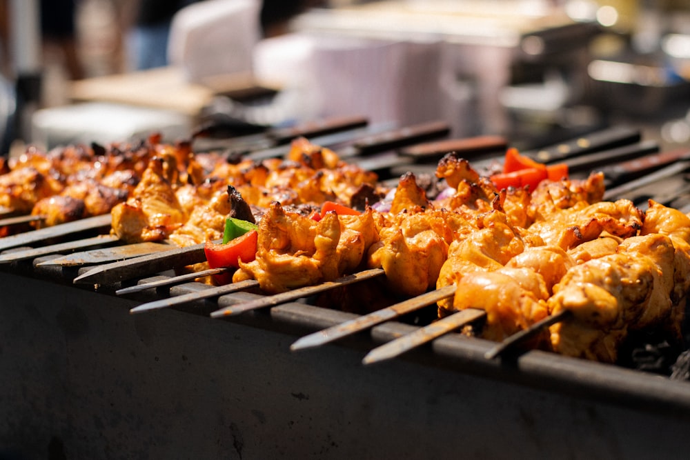 several skewers of chicken and vegetables on a grill