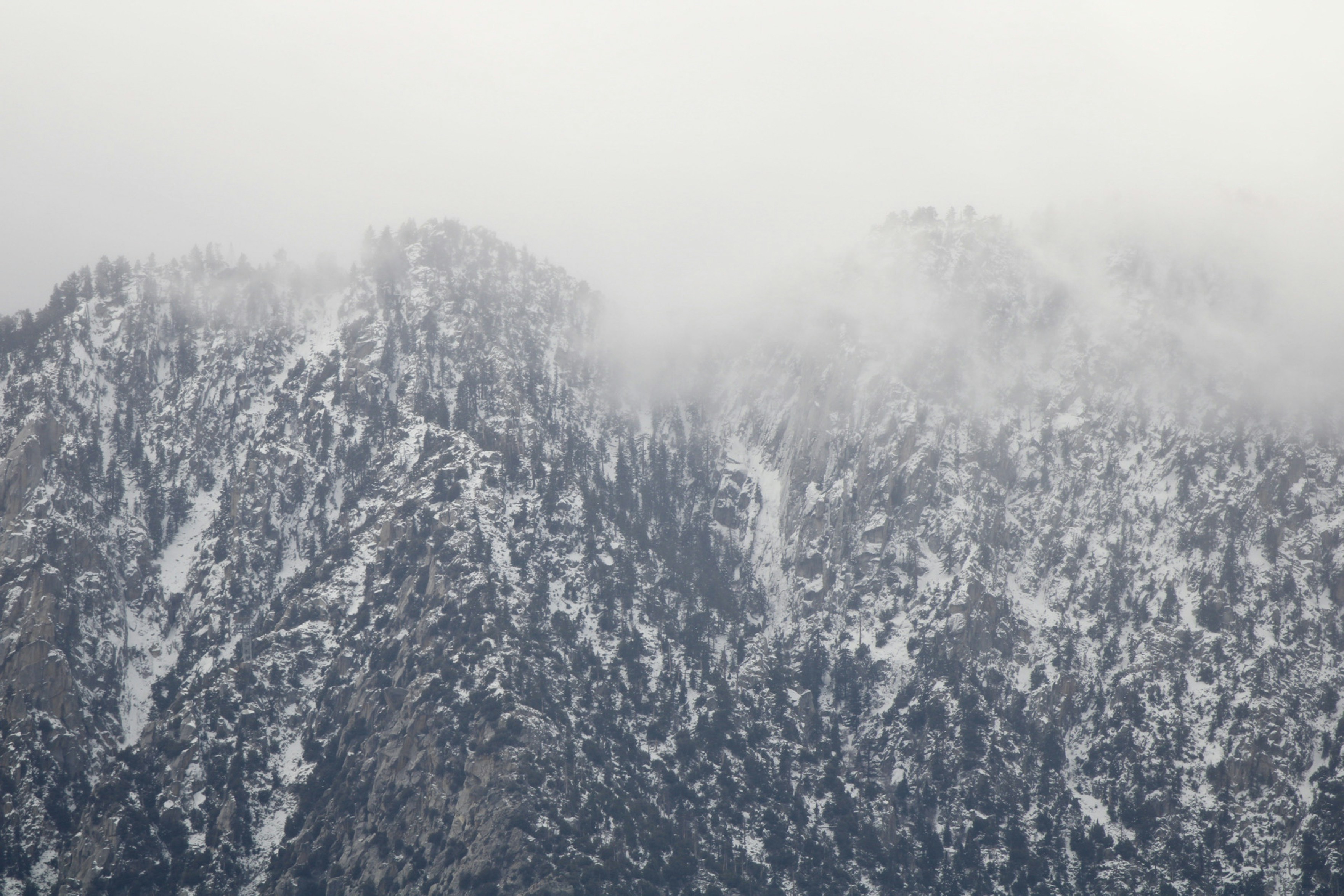 a very tall mountain covered in snow and clouds