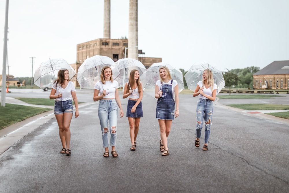 a group of women walking down a street holding umbrellas