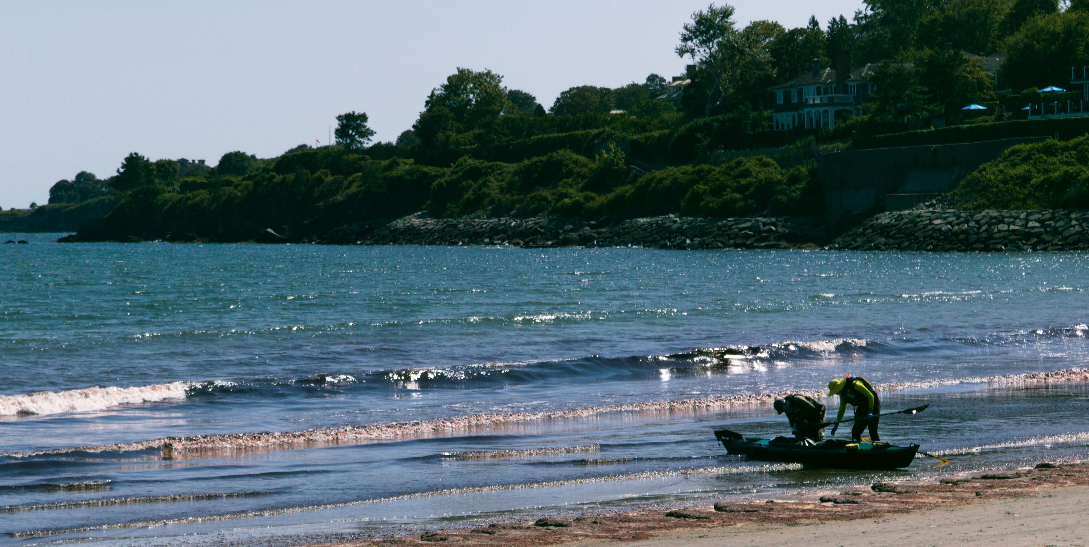 a man standing on top of a boat on top of a beach