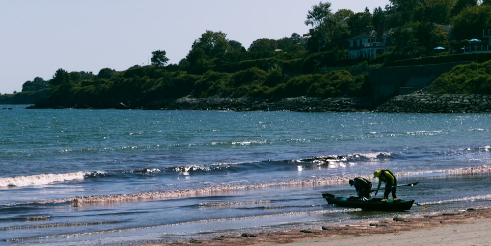 a man standing on top of a boat on top of a beach