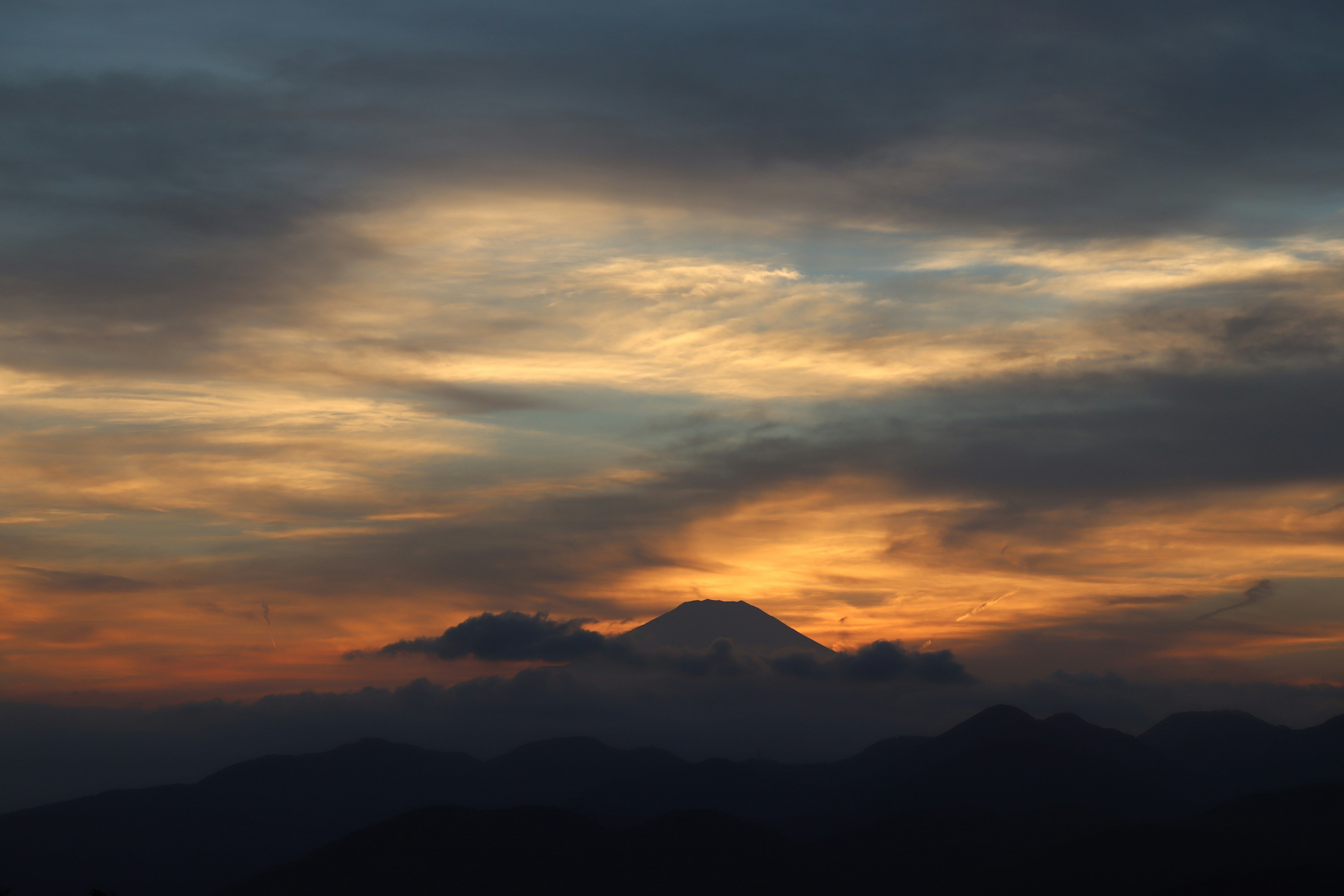 the sun is setting over a mountain range