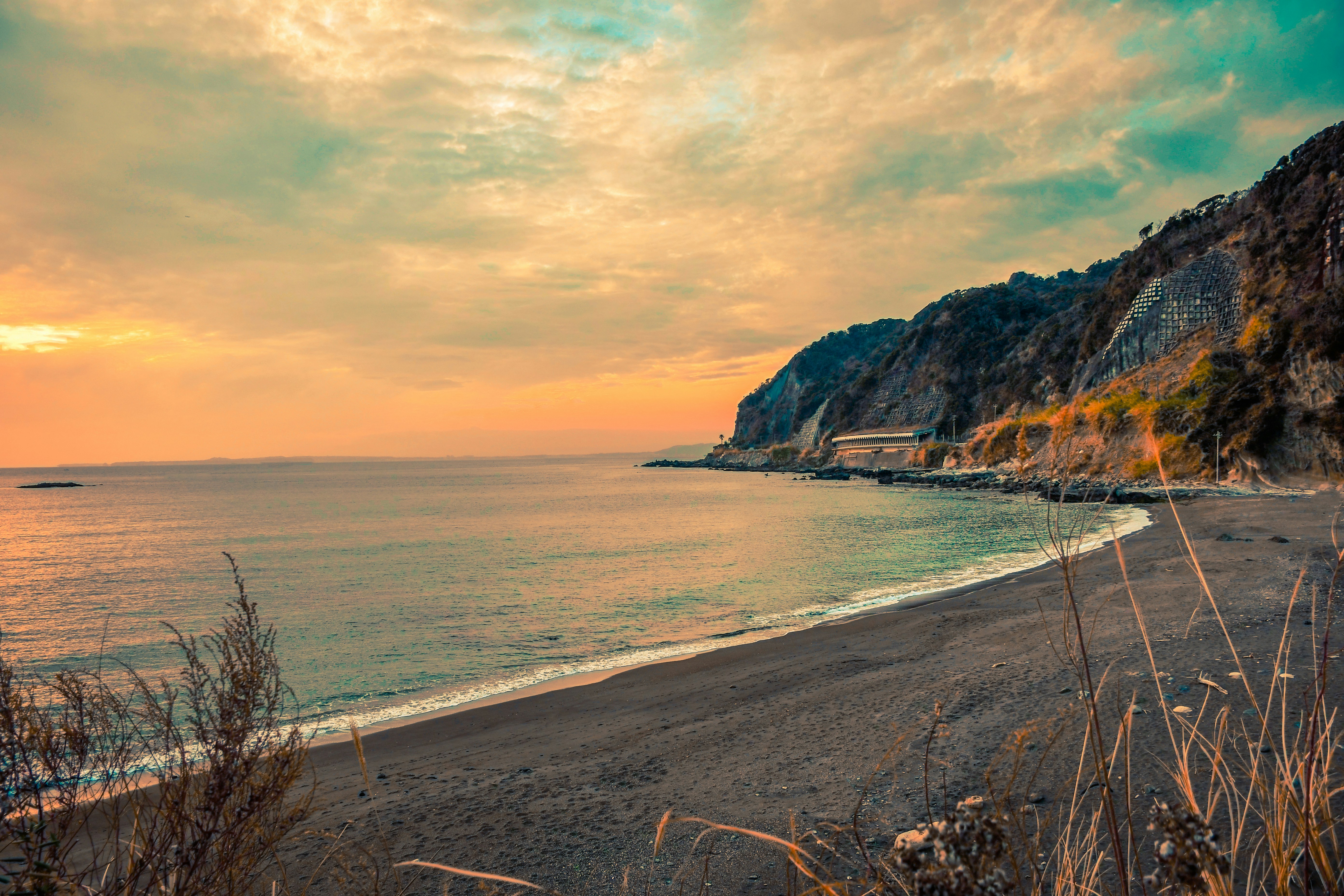 a beach with a cliff and a body of water