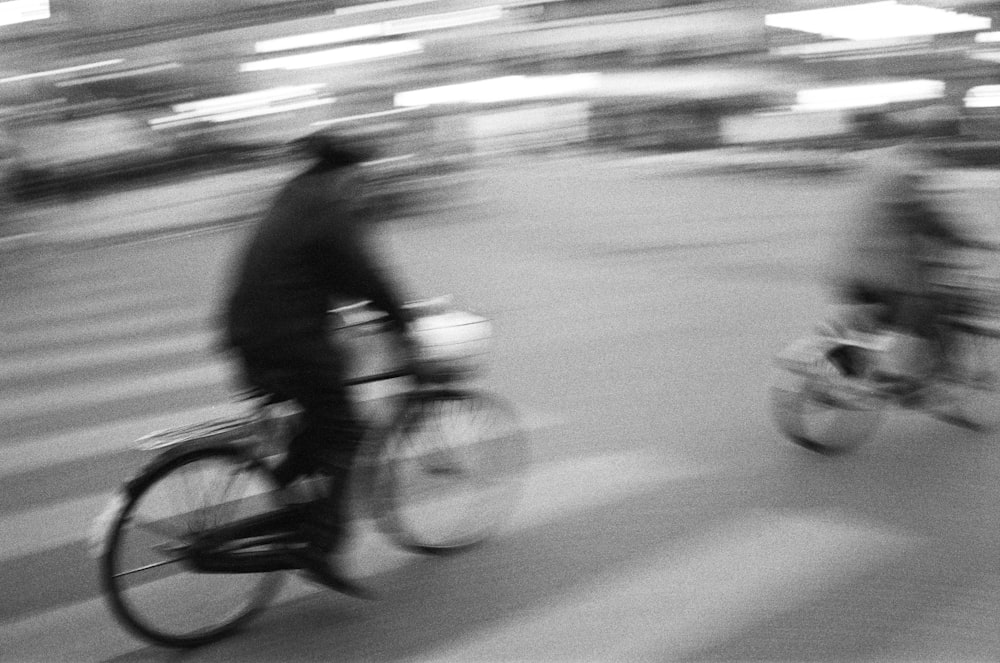 a blurry photo of two people riding bicycles