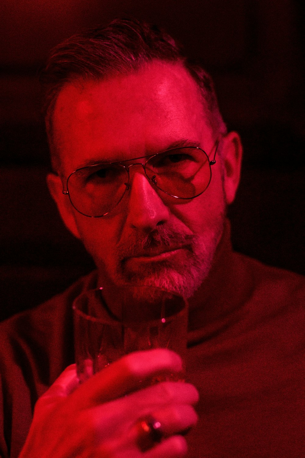 a man with glasses holding a wine glass