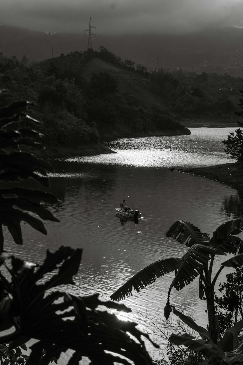 a black and white photo of a boat on a lake