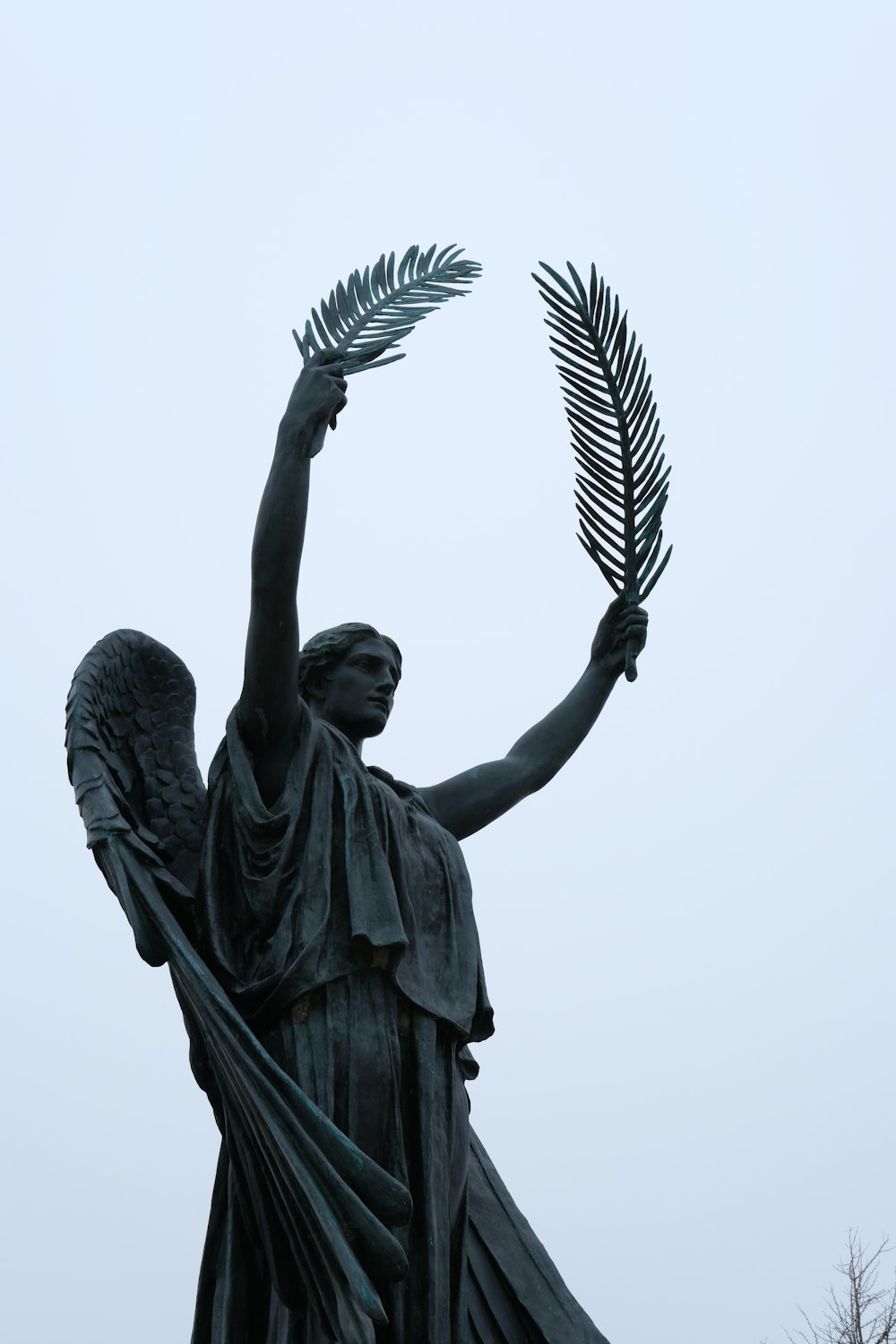 a statue of an angel holding a plant