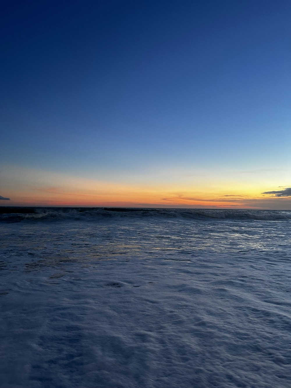 the sun is setting over the ocean on a clear day