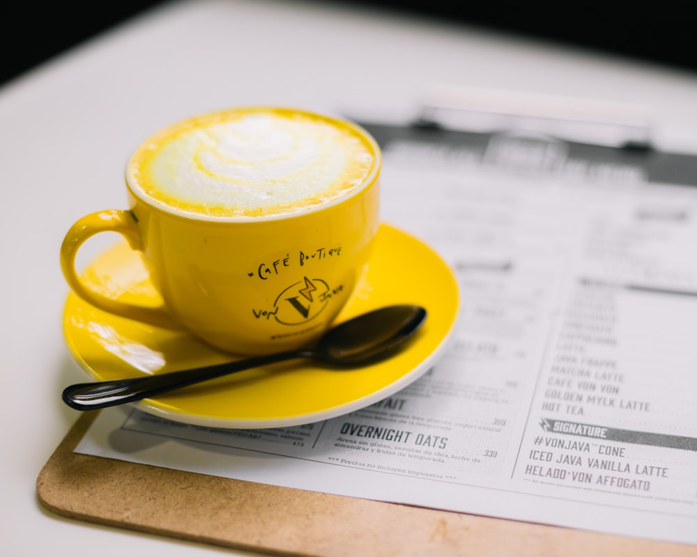 a cup of coffee sitting on top of a yellow saucer