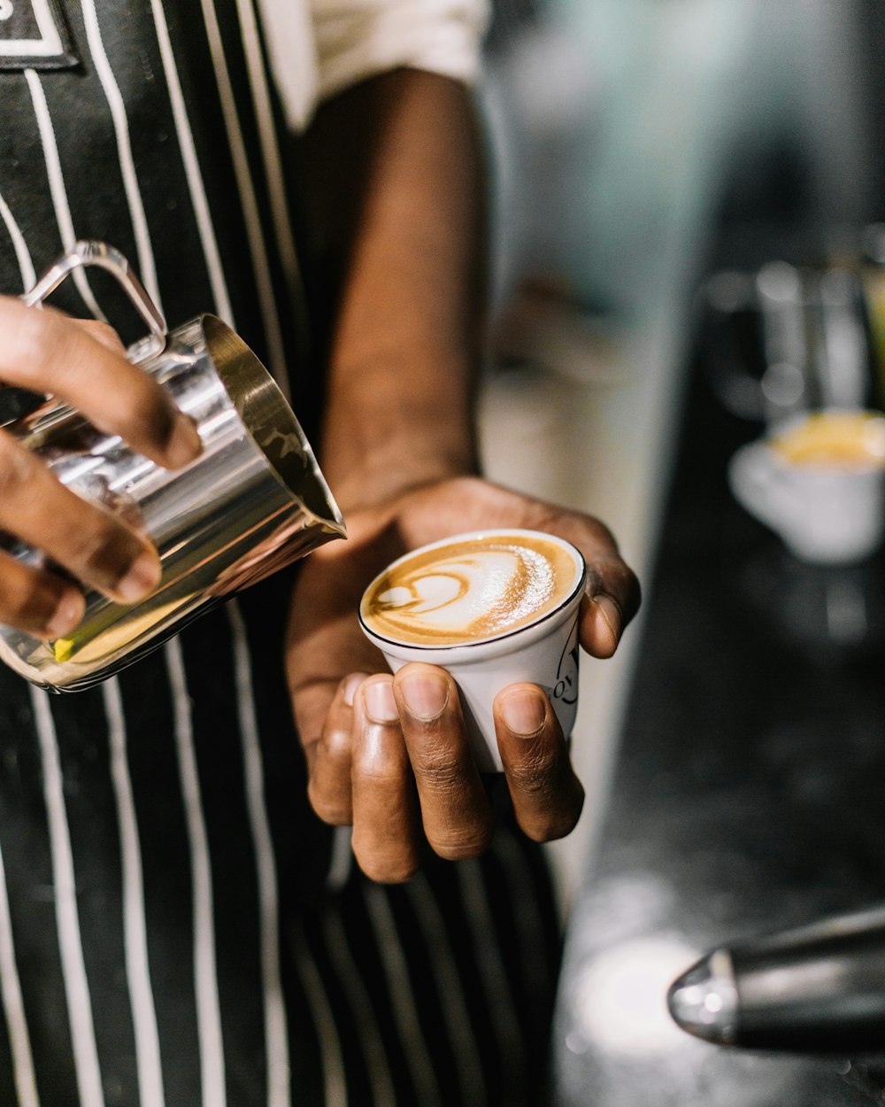 a person holding a cup of coffee in their hand