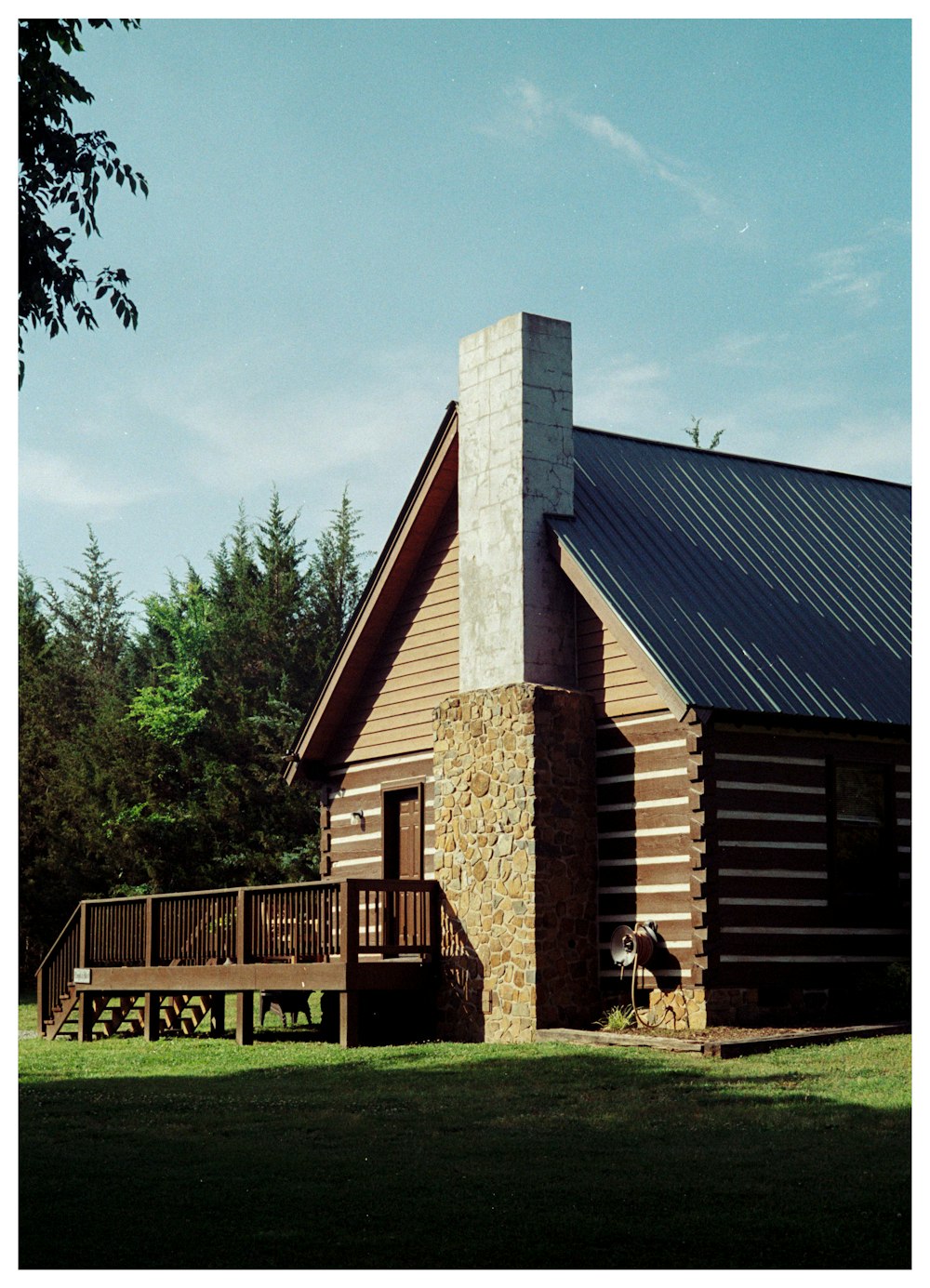 a log cabin with a porch and a stone chimney