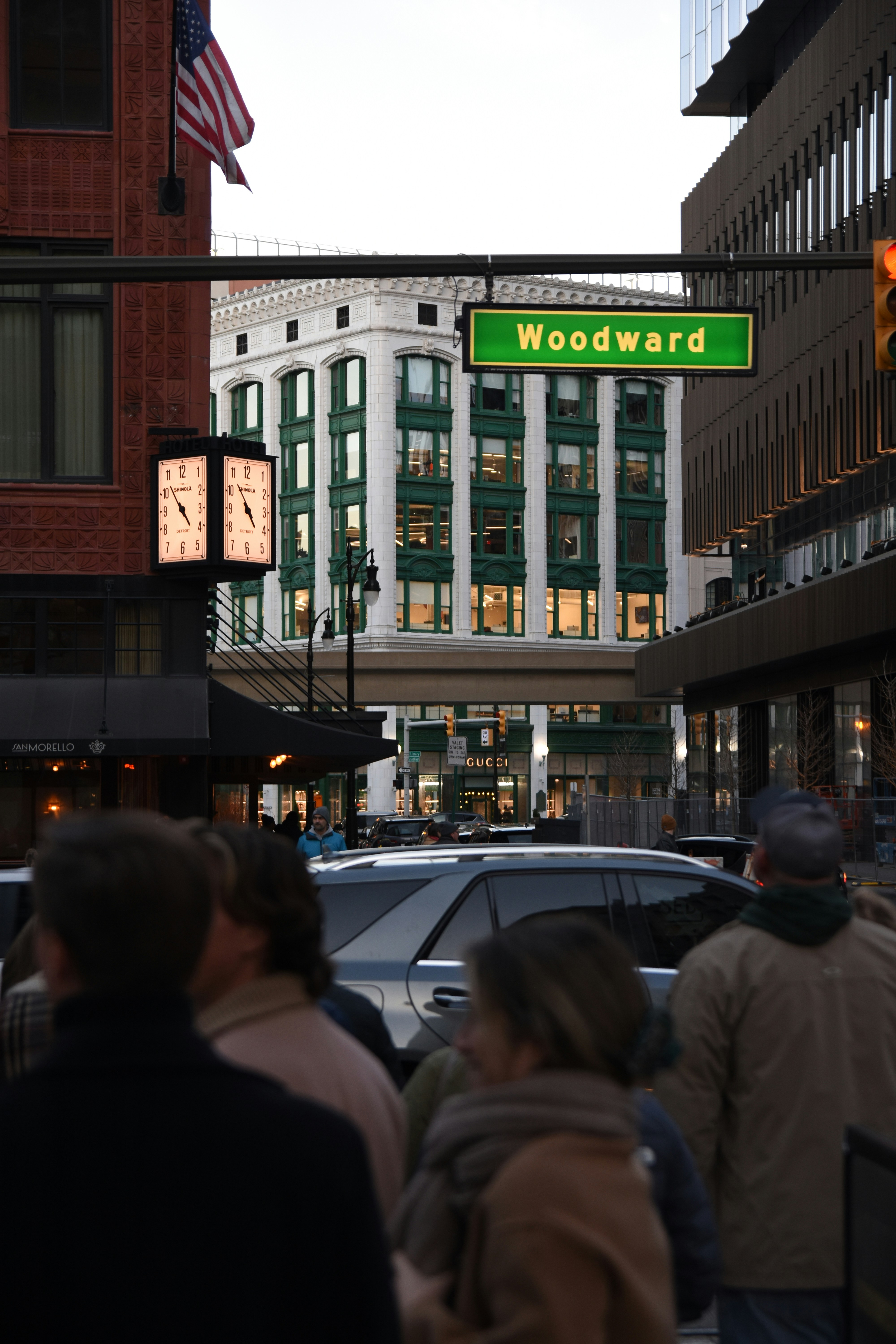 a crowd of people walking down a street next to tall buildings