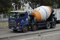 a blue and white truck driving down a street