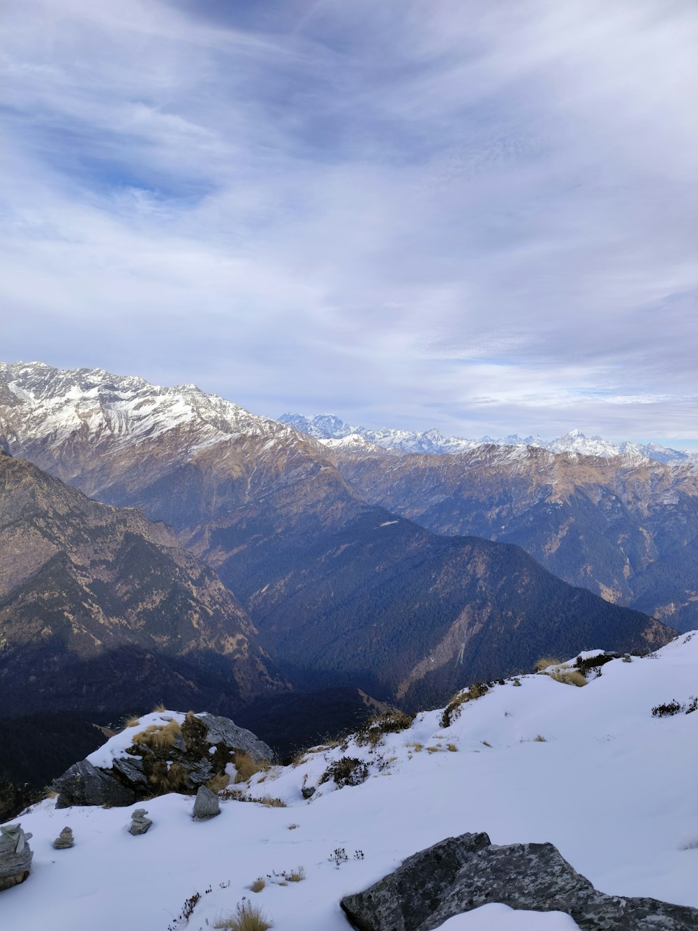 un uomo in piedi sulla cima di una montagna coperta di neve