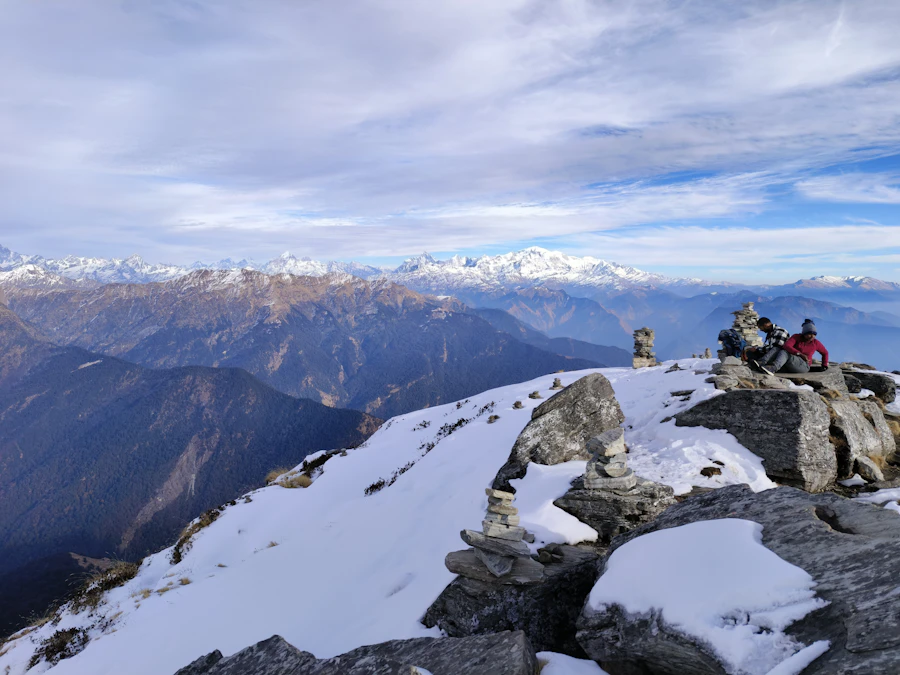 A group of trekkers seated on a snow-covered Himalayan summit