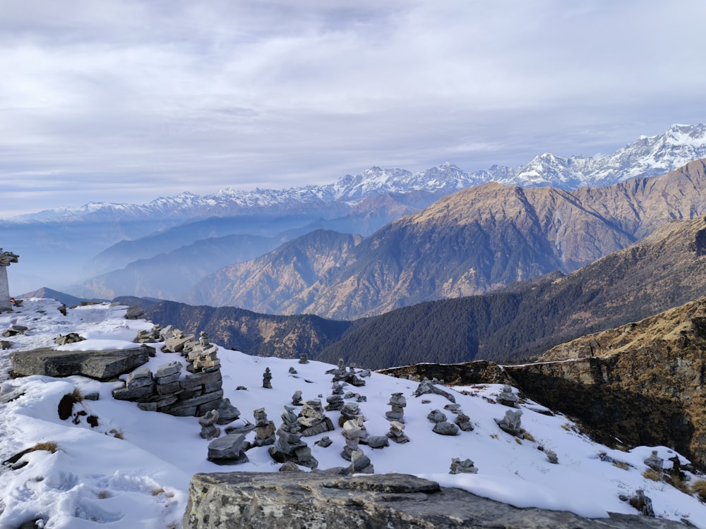 un uomo in piedi sulla cima di una montagna coperta di neve