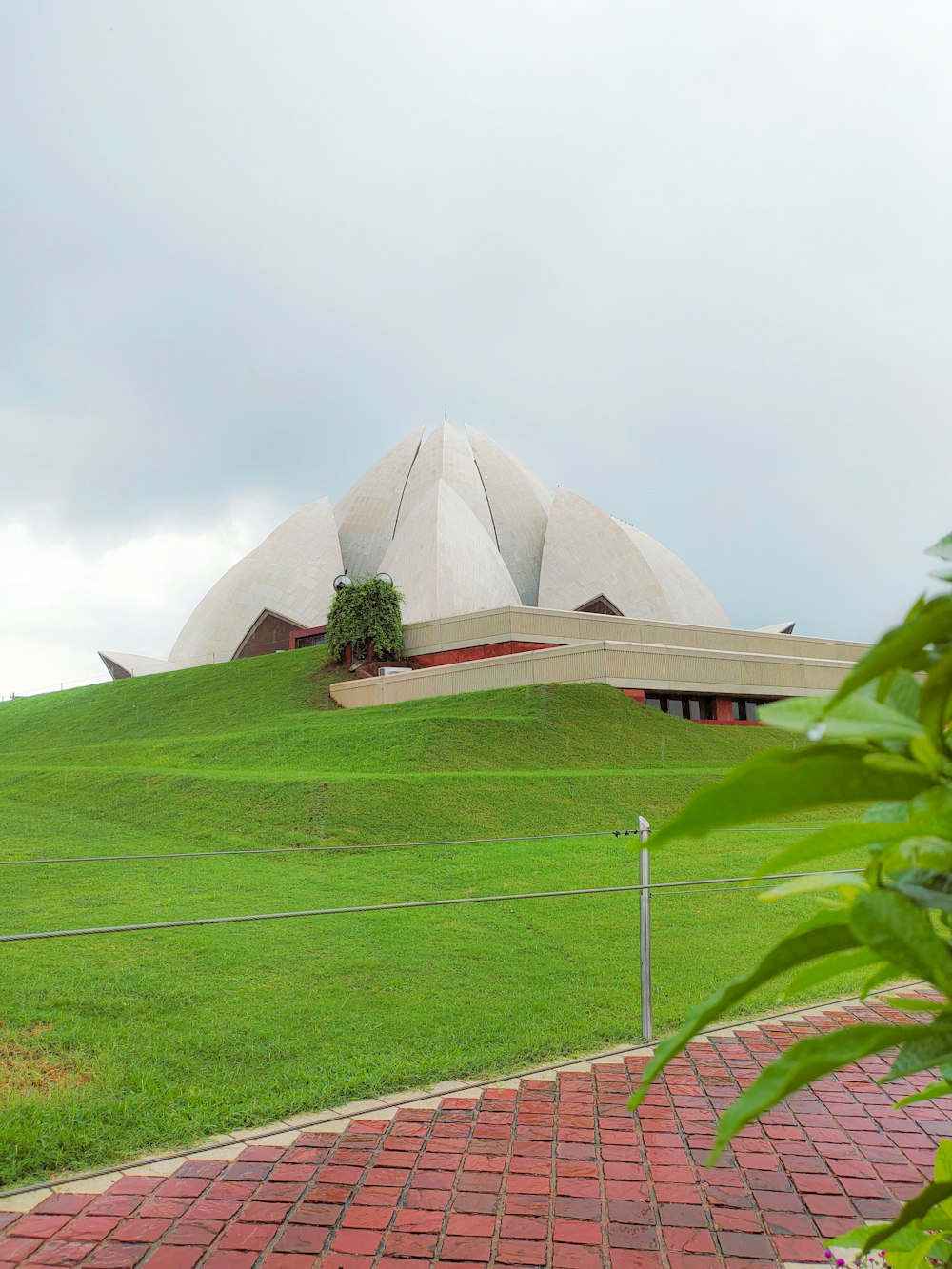 a large building sitting on top of a lush green hillside