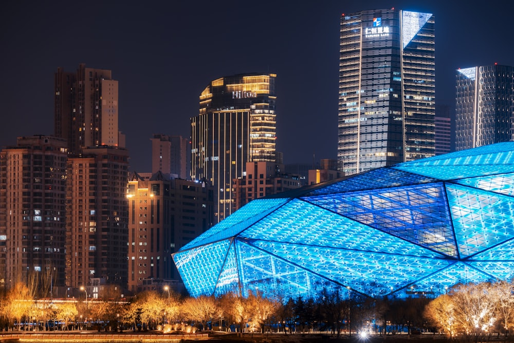 a large blue building in a city at night