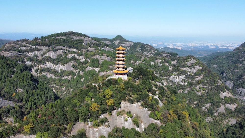 una torre alta asentada en la cima de una exuberante ladera verde