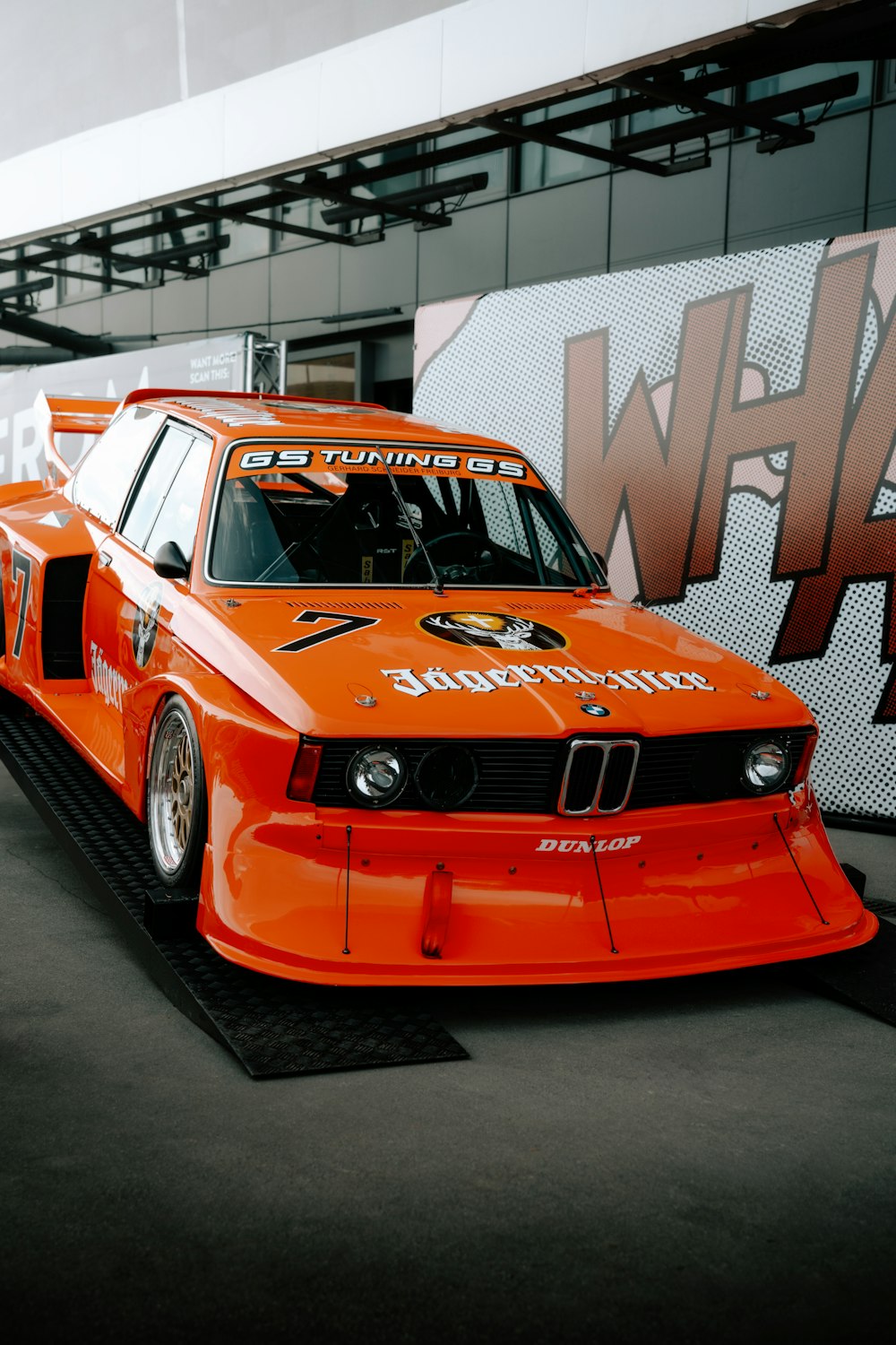 an orange race car parked in a garage