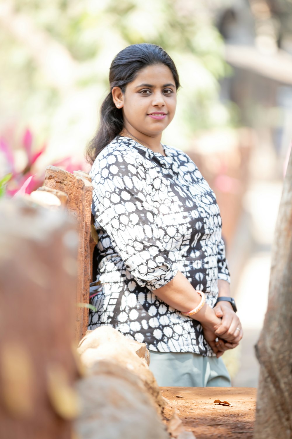 a woman standing next to a tree trunk