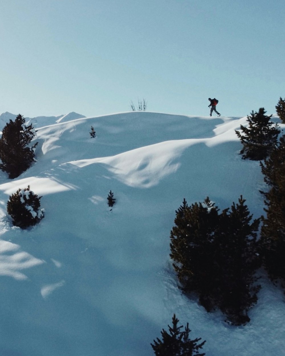 a person riding skis on top of a snow covered slope