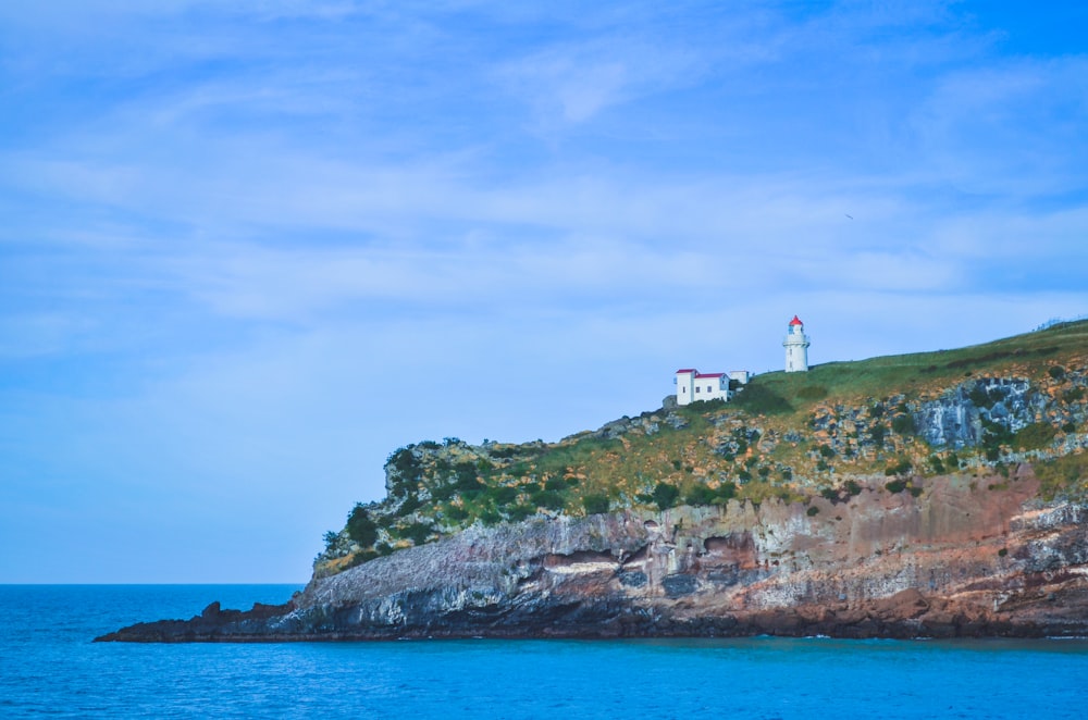 a lighthouse on top of a rocky outcropping in the ocean