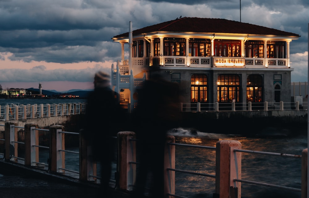 a couple of people that are standing on a pier